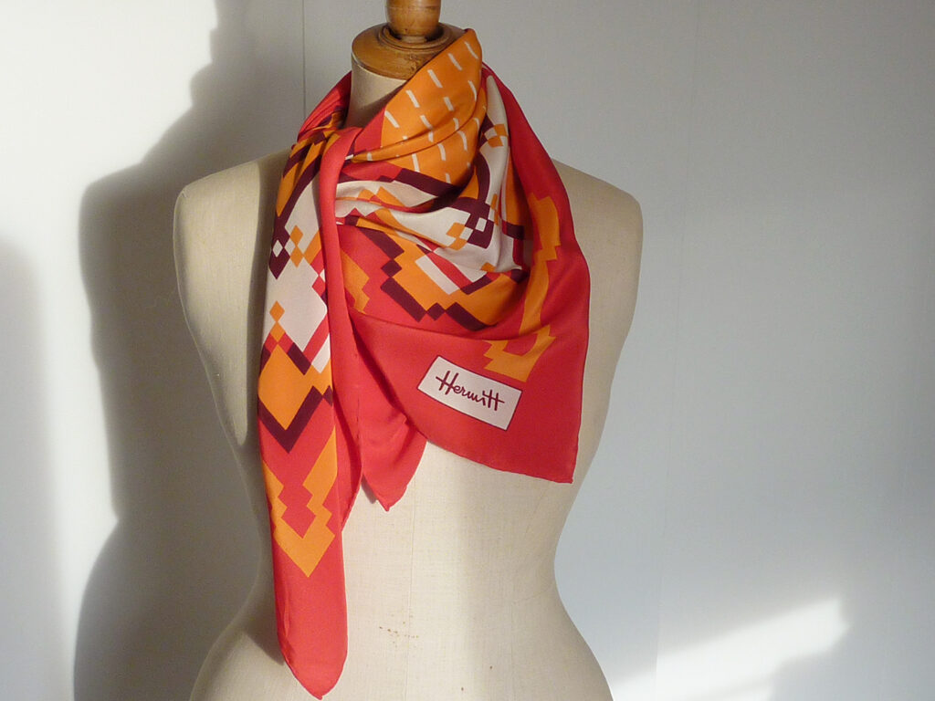 foulard vintage sur un mannequin stockman. Foulard en soie de la marque hermitt teintes automnales orange et rouge